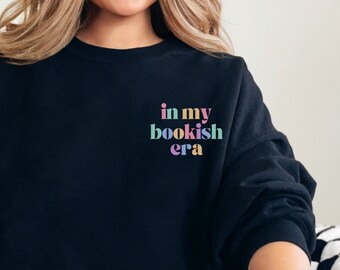 May include: A black sweatshirt with the text "in my bookish era" printed on the front in rainbow colors.