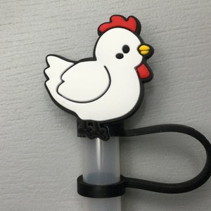 May include: White chicken-shaped silicone straw topper with red comb and yellow beak. The topper is attached to a black silicone straw holder.