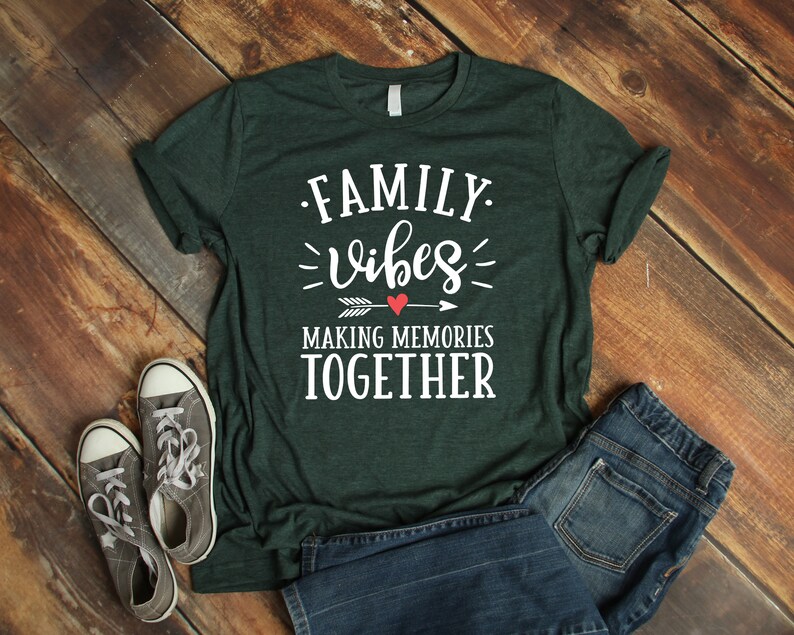 May include: A dark green t-shirt with the text "FAMILY vibes MAKING MEMORIES TOGETHER" in white lettering. A red heart and arrow are above the word "memories".