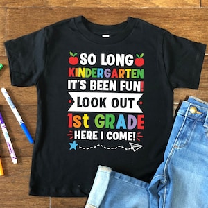May include: Black t-shirt with a colorful graphic that says "So long kindergarten it's been fun! Look out 1st grade here I come!" with a red apple, a star, and a paper airplane.