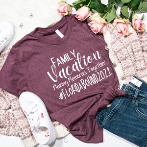 May include: A maroon t-shirt with the text "FAMILY vacation Making Memories Together #FLORIDABOUND2021" in white lettering.