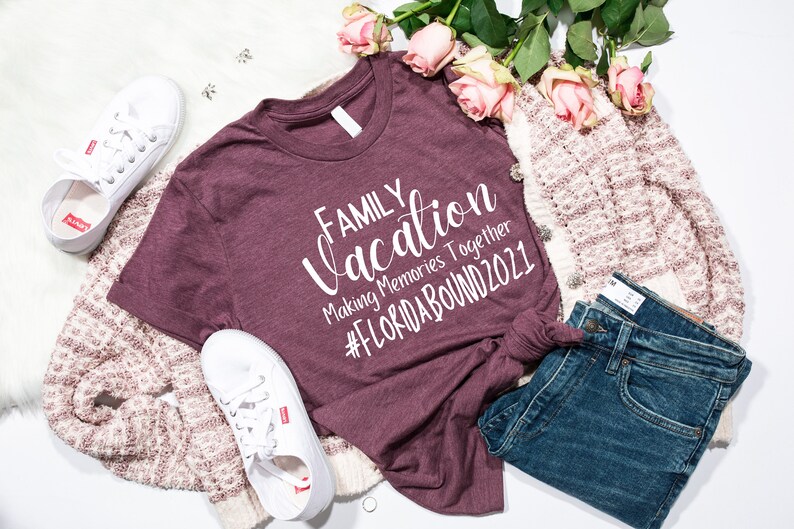 May include: A maroon t-shirt with the text "FAMILY vacation Making Memories Together #FLORIDABOUND2021" in white lettering.