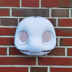 May include: White unpainted animal mask with large eye holes and a small mouth opening. The mask is made of a smooth, hard material and is ready for painting.