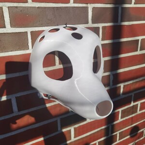 May include: White 3D printed animal mask with holes for eyes and nose. The mask is made of a smooth, white plastic and has a slightly textured surface.