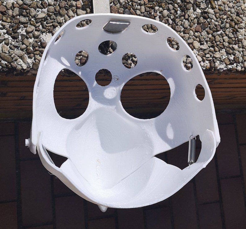 May include: White plastic helmet with multiple holes and a spring attached to the side.
