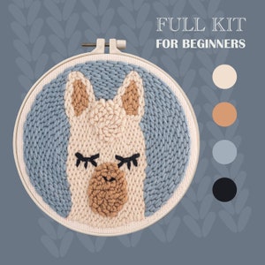 May include: A full embroidery kit for beginners featuring a llama with closed eyes. The kit includes a hoop, yarn in beige, brown, blue, and black, and a needle.