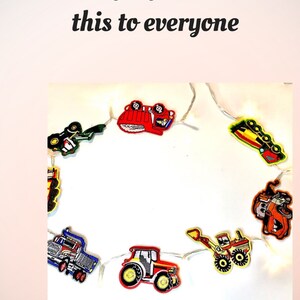 May include: A string of fairy lights with construction vehicle designs. The lights are strung together with clear wire and feature a red fire engine, a yellow bulldozer, a green tractor, a blue dumper truck, and a yellow digger. The lights are on a white background and have a five-star rating.