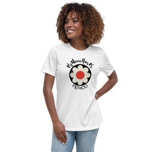 Può includere: T-shirt bianco con un design floreale e la scritta "My Uterus Hates Me PERIOD" in nero. Il fiore ha un centro rosso, petali color crema e un contorno nero. La maglietta ha una vestibilità morbida.