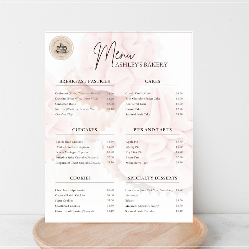 K&ouml;nnte beinhalten: Eine Speisekarte f&uuml;r Ashley's Bakery mit Fr&uuml;hst&uuml;cksgeb&auml;ck, Cupcakes, Kuchen und Torten, Keksen und Spezialdesserts. Die Speisekarte ist auf einem rosa und wei&szlig;en Hintergrund mit einem Blumenmuster gedruckt.