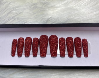 Presse scintillante rouge sur les ongles