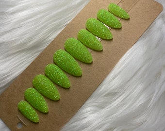 Op de afbeelding: Een set van tien groene glitter press-on nagels met een lichte groene glans.