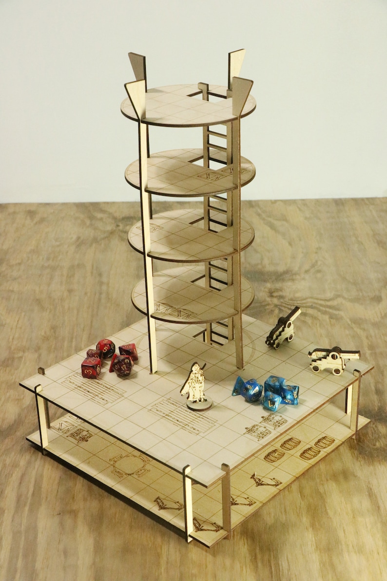 Pu&ograve; includere: Una torre di legno a cinque livelli con una scala, posta su una base quadrata con un motivo a griglia. La base comprende una figura in miniatura, dadi e piccoli cannoni di legno.