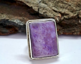 May include: A silver ring featuring a large, rectangular, purple and white gemstone set in a silver bezel.