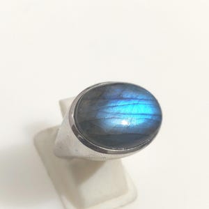 Può includere: Un anello d'argento con una grande pietra ovale di labradorite blu.