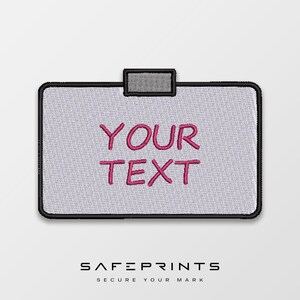 May include: Embroidered patch with the words "YOUR TEXT" in pink, centered on a light gray background. The patch has a black border and a gray tab at the top. The brand name "SAFEPRINTS" is at the bottom.