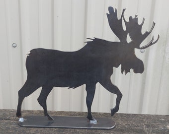May include: A black metal moose silhouette with large antlers. The moose is standing on a flat metal base.