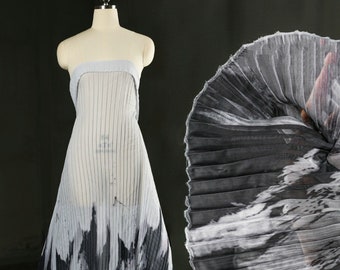 Peut inclure: Tissu plissé noir et blanc avec un motif abstrait texturé. Le tissu est drapé sur un mannequin.