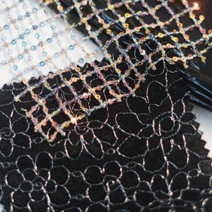 May include: Three fabric swatches, one black with a silver floral pattern, one iridescent blue and white mesh with sequins, and one iridescent pink and gold mesh with sequins.