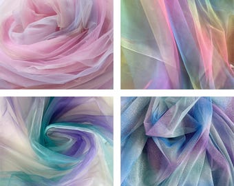 Op de afbeelding: Vier close-up opnamen van kleurrijke tule stof. De stof toont een kleurengradatie, waaronder roze, paars, blauw, groen en geel. De tule is zacht en vloeiend, met een delicate, transparante uitstraling. De stof is ideaal voor knutselen en decoratieve doeleinden.