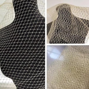 Peut inclure: Gros plan sur un tissu en filet beige à motif de losanges drapé sur un mannequin noir. Le filet a un tissage ouvert et délicat, créant un aspect texturé. Le tissu est probablement utilisé pour des voiles ou d'autres accessoires.