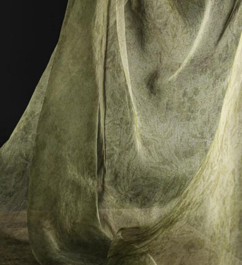 May include: A green sheer fabric with a textured pattern, draped and folded to create soft, flowing lines.