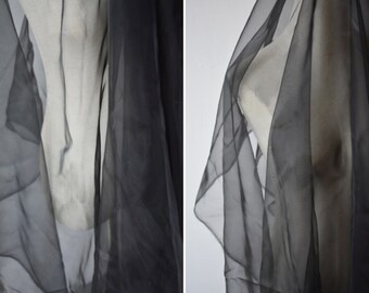 May include: Black sheer fabric draped over a mannequin. The fabric is lightweight and translucent, with a soft, flowing texture.