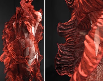 May include: Red fabric with a ruffled, layered texture. The fabric is translucent and has a slightly iridescent sheen.