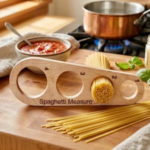 May include: A wooden spaghetti measure with four circular openings, labelled 1 to 4, and the text "Spaghetti Measure." The measure holds uncooked spaghetti. A pot of water boils in the background, along with a bowl of sauce.