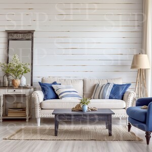 May include: A light beige sofa with blue and white striped pillows and a dark blue pillow. The sofa is in front of a white wood plank wall. A dark wood coffee table sits in front of the sofa. A blue armchair is to the right of the sofa. A small potted plant sits on the coffee table.
