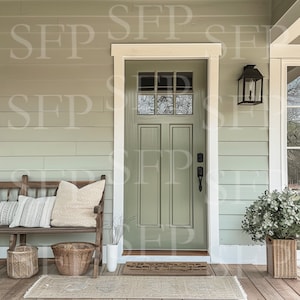 May include: A green front door with a white frame and a glass panel. A wooden bench with pillows sits on a porch with a welcome mat and a potted plant.