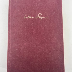May include: A burgundy book with the name "William Styron" written in gold lettering on the front cover.