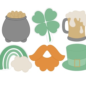 May include: Set of eight St. Patrick's Day themed cutouts. The cutouts include a pot of gold, a four-leaf clover, a beer mug, a rainbow, a mustache, and a leprechaun hat.