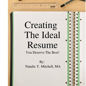 May include: A notebook with a green and white grid pattern and a black spiral binding. The notebook has the text "Creating The Ideal Resume" and "You Deserve The Best!" written on it. The text "By: Natalie Y. Mitchell, MA" is also written on the notebook. The notebook is on a wooden surface with a ruler and pencil.
