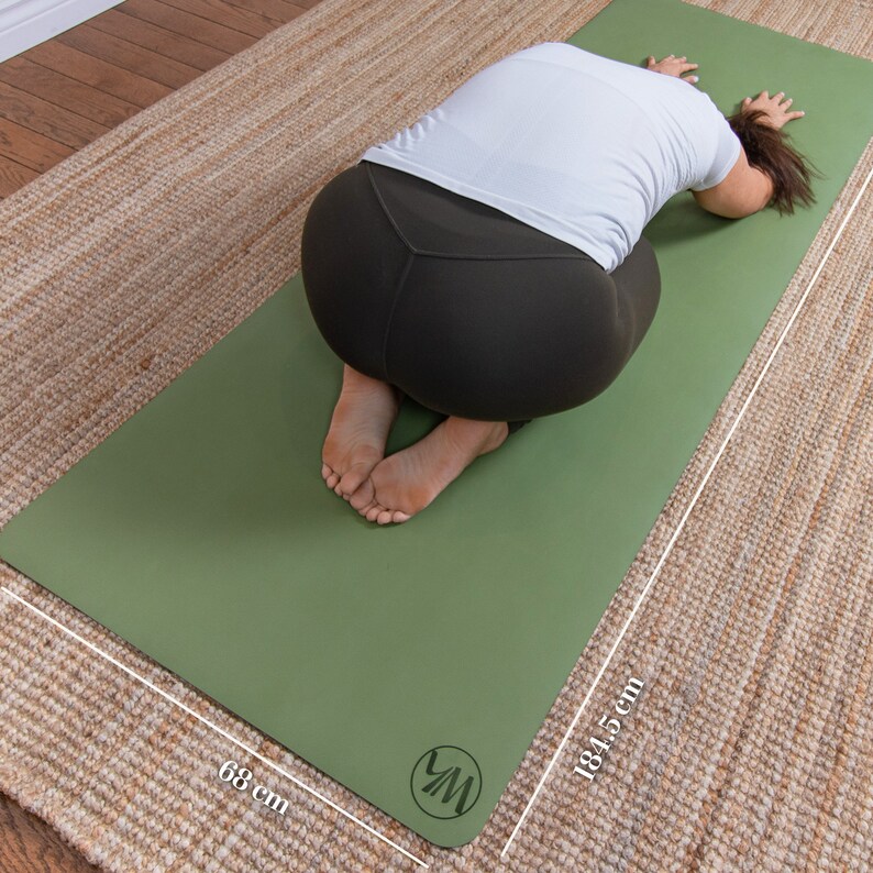K&ouml;nnte beinhalten: Eine gr&uuml;ne Yogamatte mit einem wei&szlig;en Logo in der rechten unteren Ecke. Die Matte misst 68 cm x 184,5 cm.