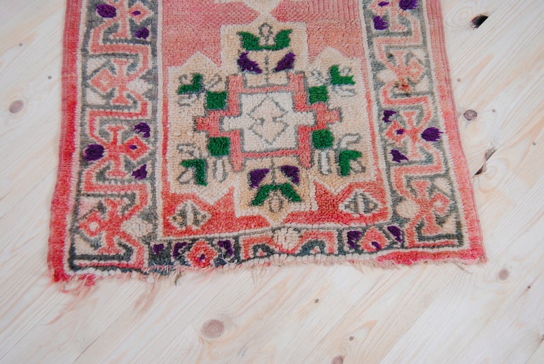 Puede incluir: Una alfombra peque&ntilde;a y rectangular con un dise&ntilde;o persa tradicional. La alfombra est&aacute; hecha de lana y tiene una combinaci&oacute;n de colores rojo, verde y blanco.