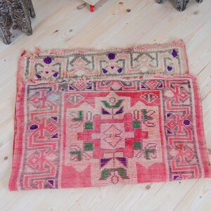 Puede incluir: Una alfombra turca vintage con fondo rojo y intrincados patrones geom&eacute;tricos en tonos de rosa, verde y morado.