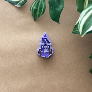 May include: Purple plastic cookie cutter shaped like a castle with a cloud base.