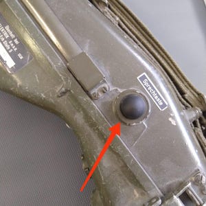 Può includere: Una radio militare verde con un pulsante nero "Sprechtaste" per parlare.