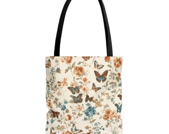 May include: Tote bag with a cream background, featuring a floral and butterfly pattern in shades of orange, blue, and brown. The bag has a black handle.