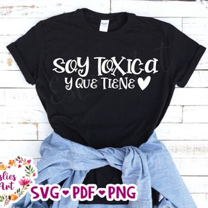 Puede incluir: Camiseta negra con texto blanco que dice "Soy Toxica y que tiene" con un corazón blanco.