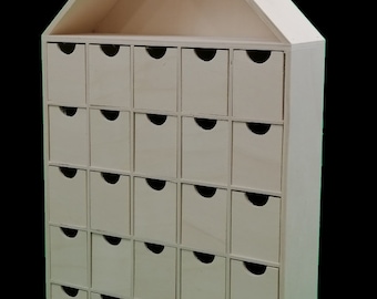 Advent calendar. In natural poplar wood. To paint. With 24 drawers. Measurements (width/depth/height): 28*8*48 cm.