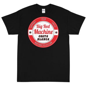 Op de afbeelding: Zwart T-shirt met een rood en wit cirkelvormig logo met de tekst "Support Your Local Big Red Machine Costa Blanca Motorcycle Club".