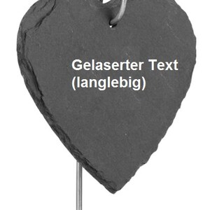 May include: A black heart-shaped slate plaque with a metal ring at the top and a metal stake on the bottom. The plaque has the text "Gelaserter Text (langlebig)" engraved on it.