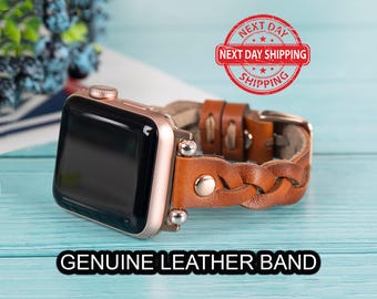 May include: A brown leather watch strap with a braided design. The strap is compatible with Apple Watch and has a rose gold finish. The strap is shown on a blue surface.