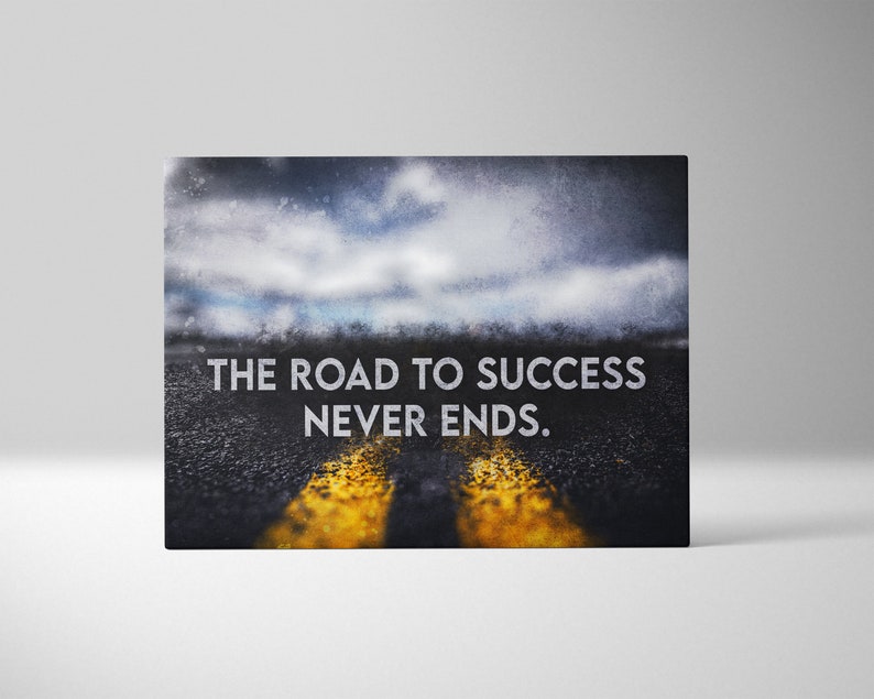 K&ouml;nnte beinhalten: Leinwanddruck mit einer Stra&szlig;e mit gelben Linien unter einem bew&ouml;lkten Himmel. Der wei&szlig;e Text lautet "THE ROAD TO SUCCESS NEVER ENDS". Das Bild hat ein motivierendes Thema, geeignet f&uuml;r die Dekoration und um zu inspirieren.