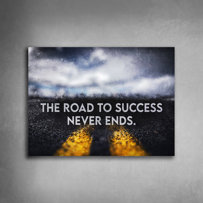 K&ouml;nnte beinhalten: Motivierender Leinwanddruck mit einer Stra&szlig;e mit gelben Linien, die zu einem bew&ouml;lkten Himmel f&uuml;hren. Der wei&szlig;e Text lautet "THE ROAD TO SUCCESS NEVER ENDS" und vermittelt eine Botschaft der Ausdauer und des Erfolgs.