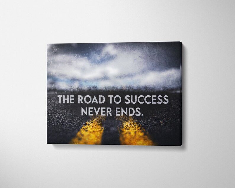 K&ouml;nnte beinhalten: Leinwanddruck mit einer Stra&szlig;e mit gelben Linien, die zu einem verschwommenen Horizont unter einem bew&ouml;lkten Himmel f&uuml;hrt. Der Text "THE ROAD TO SUCCESS NEVER ENDS" ist in Wei&szlig; dargestellt.