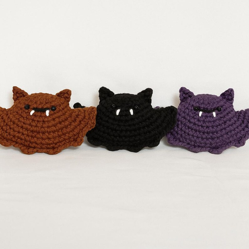 Puede incluir: Tres murci&eacute;lagos de ganchillo en marr&oacute;n, negro y morado. Cada murci&eacute;lago tiene colmillos blancos y peque&ntilde;os ojos negros. Los murci&eacute;lagos hechos a mano tienen un aspecto texturizado, perfectos para decoraciones de Halloween o regalos tem&aacute;ticos.