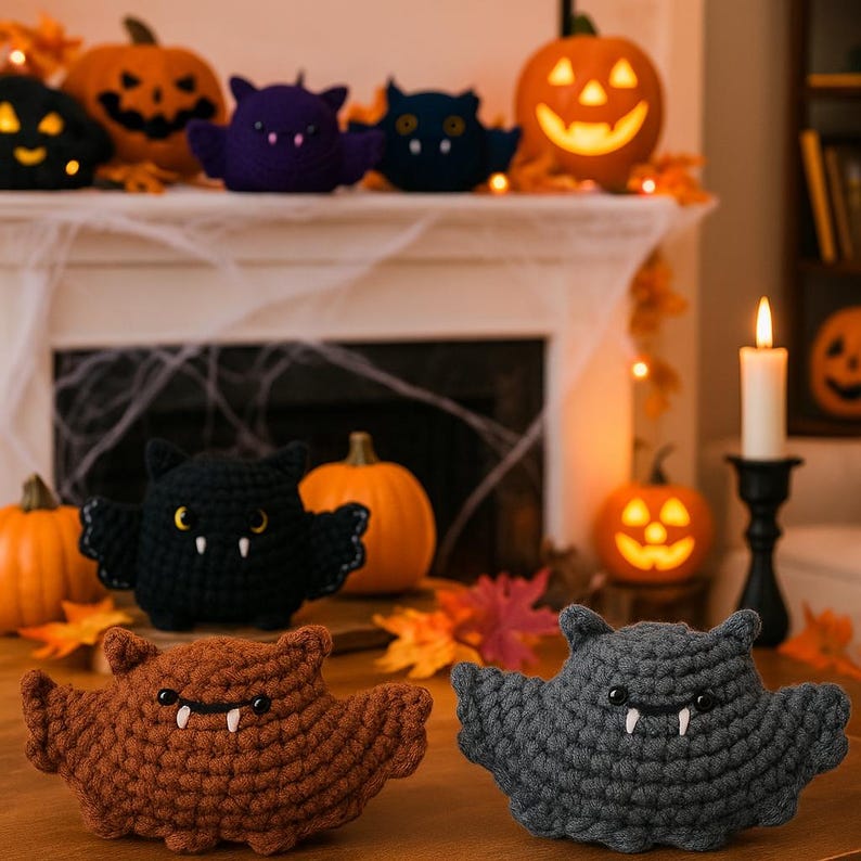 Puede incluir: Murci&eacute;lagos de Halloween de ganchillo en marr&oacute;n, negro y gris con colmillos blancos y ojos amarillos. Los murci&eacute;lagos tienen las alas extendidas y se exhiben con calabazas talladas y una vela encendida.