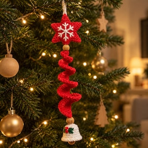 Peut inclure: Une décoration en crochet rouge en forme d'étoile avec une broderie flocon de neige blanche, reliée à une queue en spirale crochetée rouge et une cloche crochetée blanche avec des baies de houx vertes et rouges.